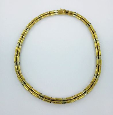 gros plan d'un bracelet en or sur une surface blanche