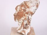 an image of a sculpture of a head on a wooden block