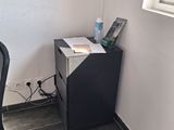 a desk with a computer and a chair in the corner