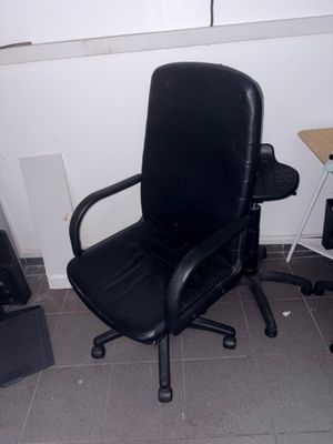 une chaise de bureau noire dans un coin de la pièce