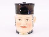 une figurine en céramique représentant un homme coiffé d'un chapeau