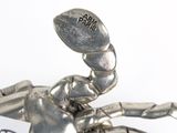 a silver figurine of a scorpion holding a football