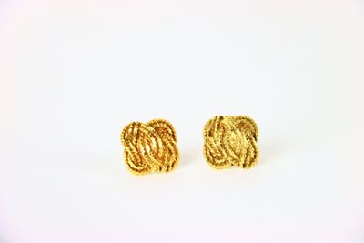 une paire de boucles d'oreilles en or sur fond blanc