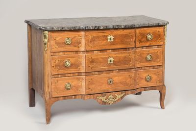 an antique chest of drawers with marble top and brass handles