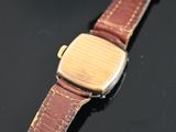 a watch that is sitting on a table next to a cell phone