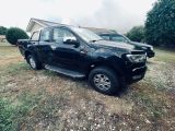 une photo d'un pick-up noir garé dans un champ