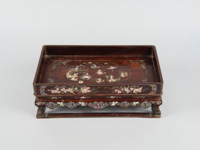 un petit plateau en bois orné de fleurs et de feuilles