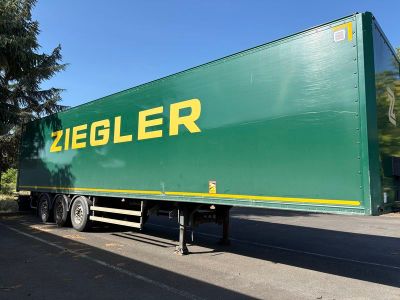 un gros camion vert garé sur le bord de la route