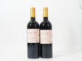 deux bouteilles de vin rouge posées sur une table blanche