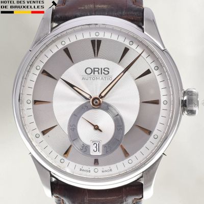 a silver watch with a brown leather strap on it