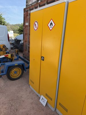une armoire jaune sur laquelle est accrochée une pancarte, à côté d'une camionnette blanche