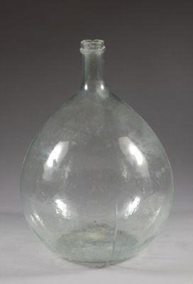a clear glass bottle with a small amount of water in it