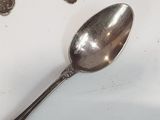 a silver spoon sitting on top of a white table