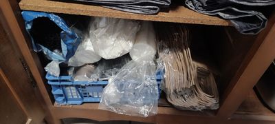 une étagère remplie de vêtements et d'autres objets dans une pièce