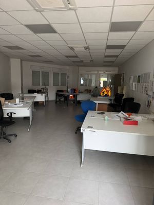 une salle où se trouvent de nombreux bureaux et chaises