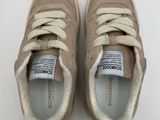 a close up of a pair of beige sneakers on a white surface