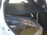 a white car with its door open and a plastic bag in the trunk
