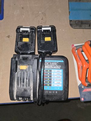 deux batteries et un chargeur posés sur une table