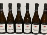 six bouteilles de vin sont alignées sur une table