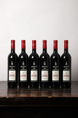 six bouteilles de vin rouge alignées sur une table en bois
