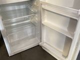 an open refrigerator with the door open and a microwave in it