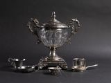 a silver cup sitting on top of a table next to a tea set