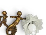 two wall sconces with a statue of a woman and a flower
