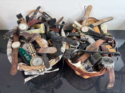 two baskets filled with different types of watches on a table