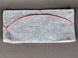 un gros plan sur un sac gris muni d'un cordon rouge