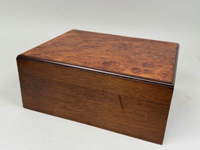 une petite boîte en bois avec un couvercle sur une surface blanche