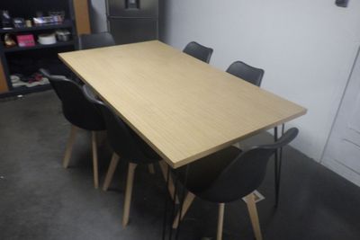 des tables et des chaises dans une pièce avec une bibliothèque en arrière-plan