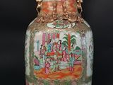 a vase with a painting on it sitting on a table