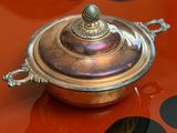 a silver plate with a lid sitting on a red table