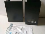 two black speakers sitting next to each other on a table