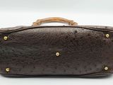 an ostrich leather handbag with gold studding and handles