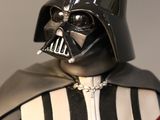 darth vader is holding a red light saber in his right hand