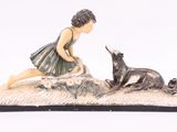figurine représentant une fillette et un chien sur un tapis