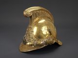a close up of a gold helmet on a black background