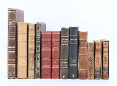plusieurs vieux livres sont alignés sur une surface blanche