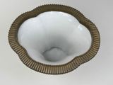 a white bowl with a gold rim on a white table