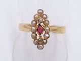 a close up of a gold ring with pearls and a pink stone