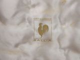 a close up of a white shirt with a gold rooster on it