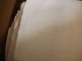 a close up of a folded white towel on a bed