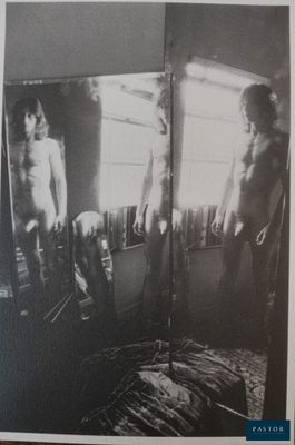 photographie en noir et blanc de deux hommes nus debout devant un miroir