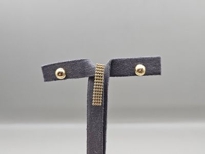 une paire de boucles d'oreilles en daim noir avec des clous dorés