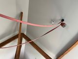 a pink ribbon tied to a pole in the corner of a room