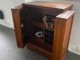 a wooden cabinet with a door open in a room