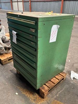 une caisse verte posée sur une palette dans un entrepôt