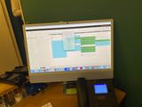 a desktop computer sitting on a desk next to a telephone