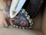 a box filled with assorted items including a mask and a knife